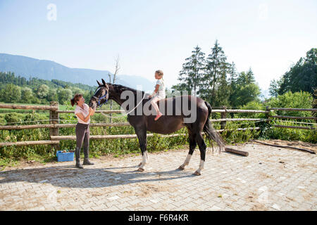 Poco ragazza seduta a cavallo Foto Stock