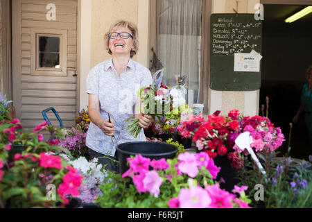 Fiorista femmina holding mazzo di fiori Foto Stock