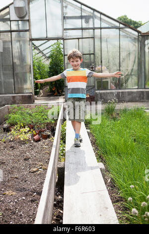 Ragazzo giocando nella parte anteriore della serra Foto Stock