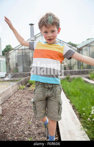 Ragazzo giocando nella parte anteriore della serra Foto Stock