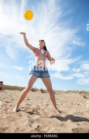 Giovane donna a giocare a beach volley Foto Stock