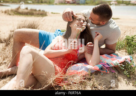 Felice coppia giovane rilassante sulla spiaggia Foto Stock