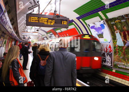 Un treno della metropolitana la linea di Piccadilly arrivando a una piattaforma Foto Stock