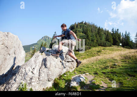 Giovane uomo escursioni nel paesaggio di montagna Foto Stock