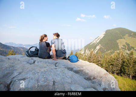 Coppia giovane in appoggio sul picco di montagna Foto Stock