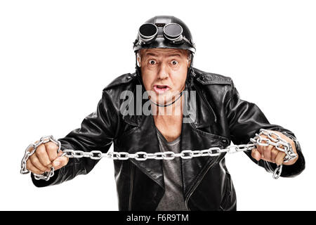 Studio shot di un violento motociclista maturo tenendo una catena di metallo e guardando la telecamera isolata su sfondo bianco Foto Stock