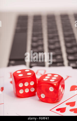 Casino chips, schede e dadi impilamento sul computer portatile Foto Stock