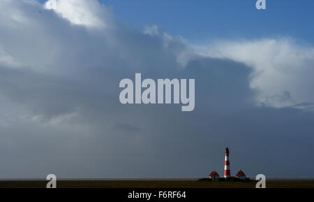 Westerhever, Germania. Xix Nov, 2015. Le nuvole si muovono attraverso il Mare del Nord e il faro in Westerhever, Germania, 19 novembre 2015. Tempesta davanti 'Iwan' porta il forte vento e pioggia per la Germania settentrionale. Foto: CARSTEN REHDER/dpa/Alamy Live News Foto Stock