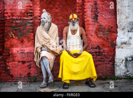 Girovagando Shaiva sadhus (uomini santi) con tradizionali dipinti faccia in un antico tempio di Pashupatinath Foto Stock