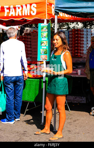 Ragazza giovane distribuendo campioni gratuiti presso il settimanale mercato degli agricoltori a Santa Barbara in California Foto Stock