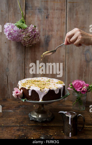 Il pistacchio e Torta di rose con mano i dadi di irrorazione Foto Stock