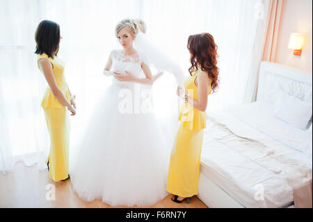 Dolce sposa bionda con damigelle in abito giallo Foto Stock