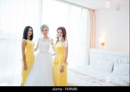 Dolce sposa bionda con damigelle in abito giallo Foto Stock