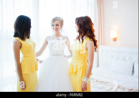 Dolce sposa bionda con damigelle in abito giallo Foto Stock