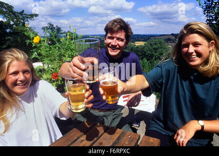 I giovani adulti aumentando il loro occhiali per la fotocamera in The Spotted Dog pub giardino. Penshurst. Kent. In Inghilterra. Regno Unito Foto Stock