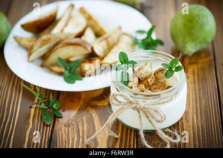 Yogurt con arrosti di pere in un vasetto di vetro Foto Stock