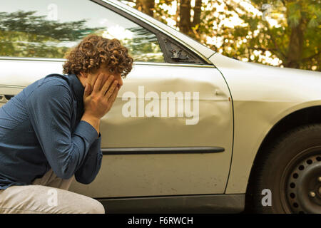 Silly uomo fa arrabbiare infastiditi espressione facciale circa dame per la sua auto Foto Stock