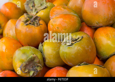 Persimmon organici frutti nella pila a livello locale mercato degli agricoltori Foto Stock