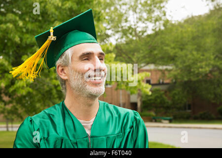 Caucasian college graduate che indossa il cappello e camice Foto Stock