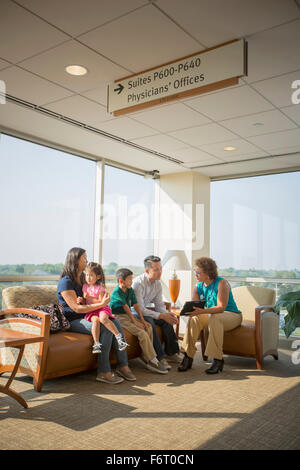 Medico parlando di pazienti in sala di attesa Foto Stock