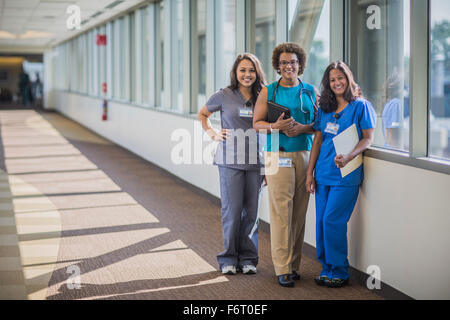 Infermieri e medico sorridente in ospedale in corridoio Foto Stock