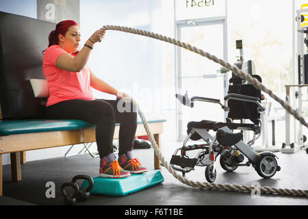 Donna disabile facendo terapia fisica in palestra Foto Stock