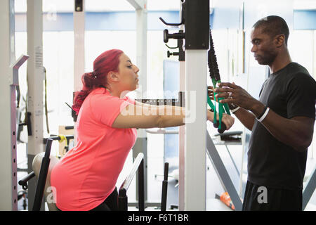 Donna disabile facendo terapia fisica con trainer Foto Stock