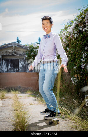 Androgino donna skateboard di equitazione Foto Stock