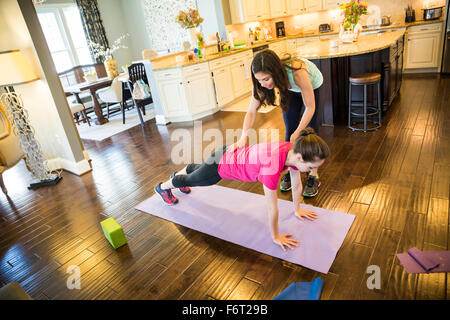 Donna che esercitano con trainer in home Foto Stock