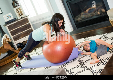 Ragazzo giocando con esercizio tappeto di madre Foto Stock