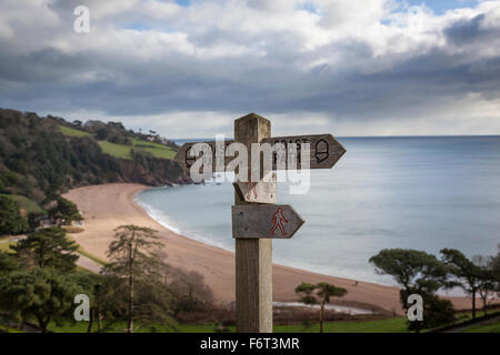 Un cartello in legno sul lato della collina che si affaccia sulla spiaggia di Blackpool guide camminatori ed escursionisti lungo il sud ovest sentiero costiero. Foto Stock