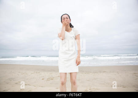 Donna che ride sulla spiaggia Foto Stock