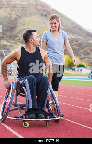 Atleta paraplegico in carrozzella con la fidanzata sulla via Foto Stock