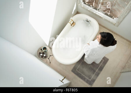 Donna con bolla bagno nella stanza da bagno