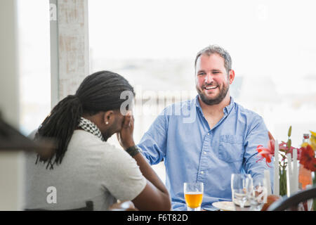 Gli uomini di ridere a cena Foto Stock