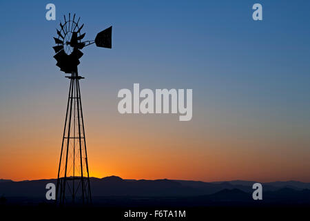 Mulino a vento stagliano contro il cielo arancione, montagne Organ, vicino a Las Cruces, Nuovo Messico USA Foto Stock