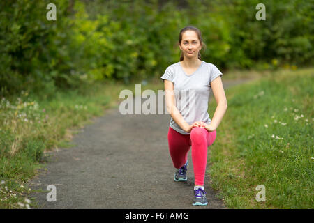 Ragazza giovane atleta facendo un warm-up prima di fare jogging nel parco. Foto Stock