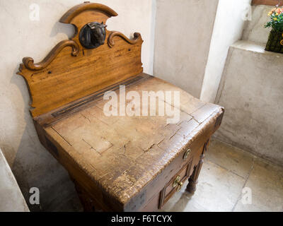 Ben utilizzati in legno del macellaio di blocco. Un bronzo testa di mucche che non lascia alcun dubbio per quanto riguarda lo scopo di questo ben indossati tagliere Foto Stock