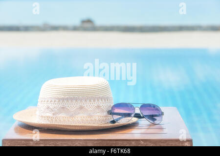 Cappello e occhiali da sole al mare sullo sfondo Foto Stock