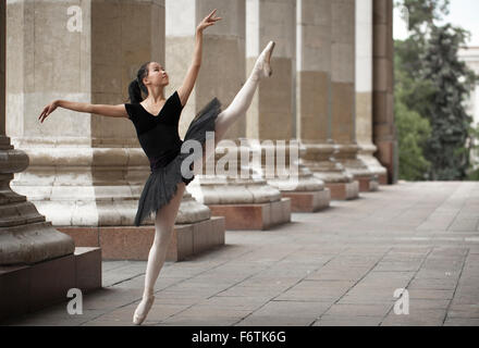 Ragazza ballerina flats permanente sulla tiptoes sulla strada Foto Stock