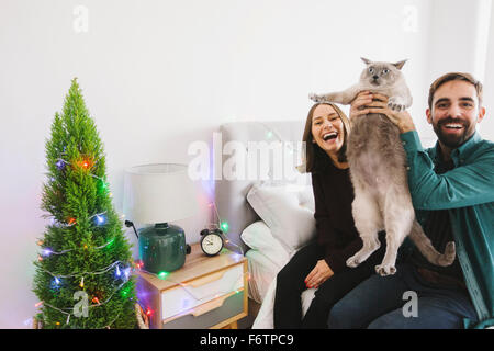 Ridendo giovane con il loro gatto a casa Foto Stock