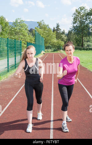 Due donne pronto a correre su una pista per la corsa Foto Stock