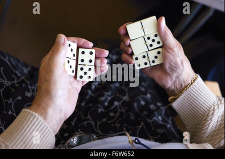 Ravvicinata di una donna anziana con le mani in mano azienda domino, Foto Stock