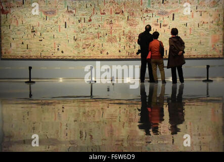 Jinan, la Cina della provincia dello Shandong. Xx Nov, 2015. I visitatori osservano la replica di un murale di Dunhuang ad una mostra di Jinan, a est della capitale cinese della provincia dello Shandong, nov. 20, 2015. Una mostra d'arte, con più di 50 repliche di Dunhuang murals, aperto venerdì. Grotte di Mogao, un sito Patrimonio Mondiale dell'UNESCO in Dunhuang della Cina nord-occidentale della provincia di Gansu, sono famose per un enorme collezione di opere d'arte buddista, che vanta più di duemila sculture colorate e 45.000 metri quadrati di pitture murali in 735 grotte scavate lungo una scogliera. Credito: Zhu Zheng/Xinhua/Alamy Live News Foto Stock