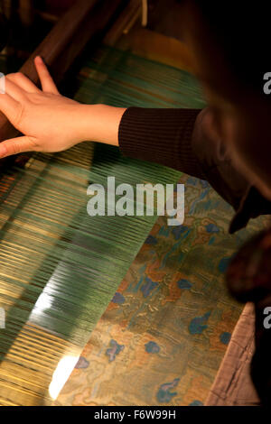 Un tessitore rendendo Shu brocade fabric con un telaio tradizionale al Shu Brocade Museum di Chengdu Sichuan in Cina. Foto Stock