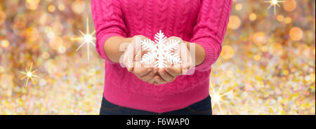 Close up della donna in maglia tenendo premuto il simbolo del fiocco di neve Foto Stock