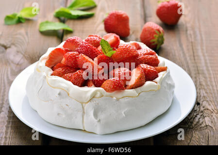 Pavlova cake con fragola sul tavolo di legno Foto Stock