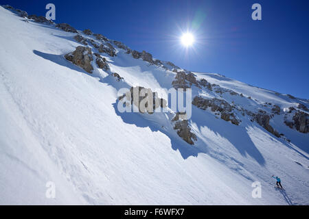 Backcountry femmina sciatore salendo attraverso bold cirque a Monte Amaro, Rava della Vespa, Maiella, Abruzzo, Italia Foto Stock