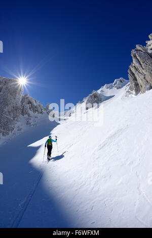 Backcountry femmina sciatore salendo attraverso coperta di neve cirque a Monte Sirente, Valle Lupara, Abruzzo, Italia Foto Stock