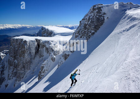 Backcountry femmina sciatore salendo attraverso coperta di neve cirque a Monte Sirente, Maiella gamma in background, Valle Lupara, Abru Foto Stock